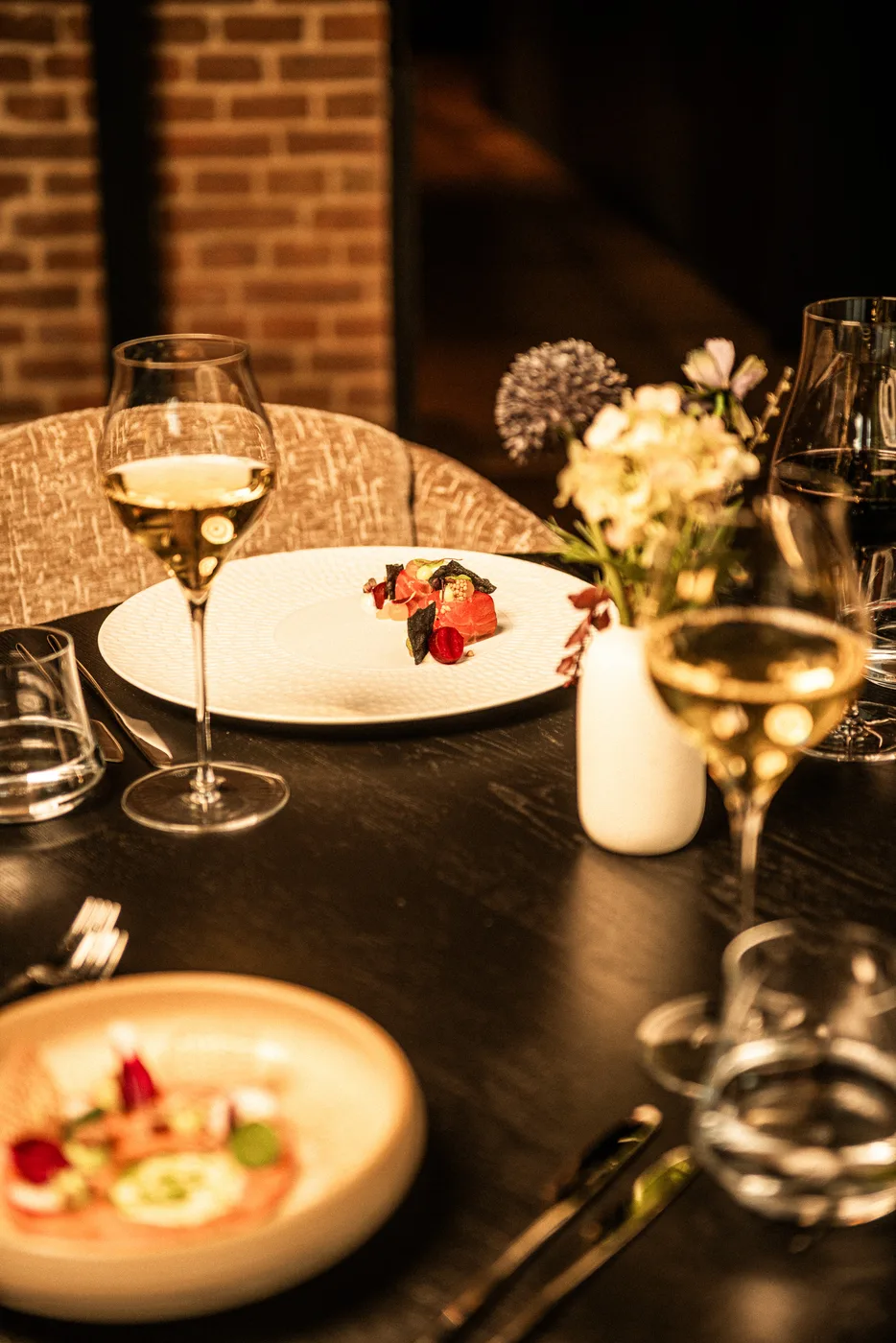 Een glas wijn en een gerecht aan tafel